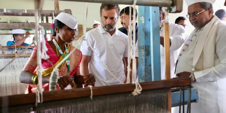 ಬದನವಾಳು ಗ್ರಾಮದಲ್ಲಿ ಖಾದಿ ಗ್ರಾಮೋದ್ಯೋಗ ಕೇಂದ್ರಕ್ಕೆ ಭೇಟಿ ನೀಡಿದ ಕಾಂಗ್ರೆಸ್ ನಾಯಕ ರಾಹುಲ್ ಗಾಂಧಿ ನೇಯ್ಕೆ ಮಾಡುತ್ತಿರುವುದನ್ನು ಪರಿಶೀಲಿಸಿದರು. ಕಾಂಗ್ರೆಸ್ ಮುಖಂಡರಾದ ಸಿದ್ದರಾಮಯ್ಯ, ಡಿ.ಕೆ.ಶಿವಕುಮಾರ್ ಜೊತೆಗಿದ್ದರು.