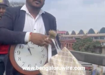 ಕತ್ತಿಗೆ ಗಡಿಯಾರ ಸಿಕ್ಕಿಸಿಕೊಂಡು, ಬ್ಯಾಗಿನಿಂದ ನೋಟುಗಳನ್ನು ಮೈಸೂರು ರಸ್ತೆ ಫ್ಲೈಓವರ್ ಮೇಲಿಂದ ಜನರತ್ತ ಎಸೆಯುತ್ತಿರುವ ಅರುಣ್ ಎನ್ನಲಾದ ವ್ಯಕ್ತಿ