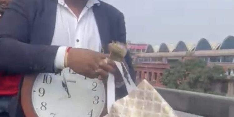 ಕತ್ತಿಗೆ ಗಡಿಯಾರ ಸಿಕ್ಕಿಸಿಕೊಂಡು, ಬ್ಯಾಗಿನಿಂದ ನೋಟುಗಳನ್ನು ಮೈಸೂರು ರಸ್ತೆ ಫ್ಲೈಓವರ್ ಮೇಲಿಂದ ಜನರತ್ತ ಎಸೆಯುತ್ತಿರುವ ಅರುಣ್ ಎನ್ನಲಾದ ವ್ಯಕ್ತಿ