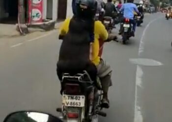 ಕಪ್ಪು ಬಣ್ಣದ ಶ್ವಾನವೊಂದು ತನ್ನ ಮಾಲೀಕನೊಂದಿಗೆ ಹೆಲ್ಮೆಟ್ ಧರಿಸಿ ಬೈಕ್ ನಲ್ಲಿ ಸಾಗುತ್ತಿರುವ ಚಿತ್ರ.